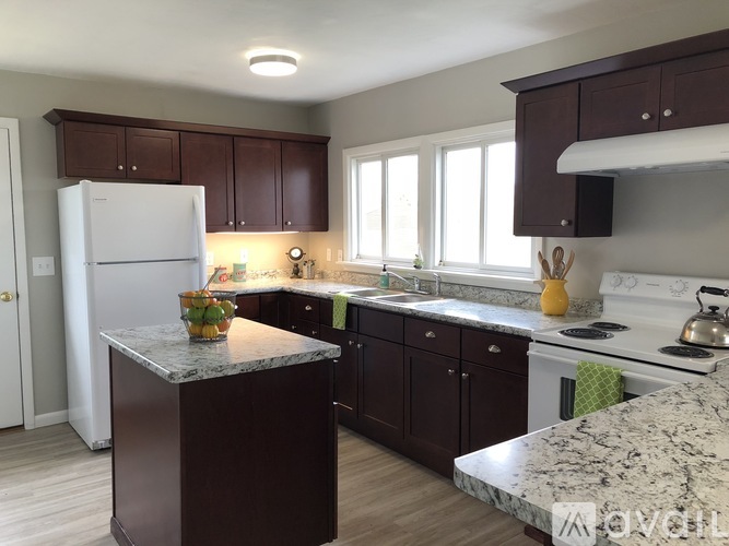 A kitchen with brown cabinets and a white refrigerator.