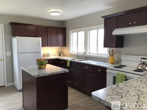 A kitchen with brown cabinets and a white refrigerator.