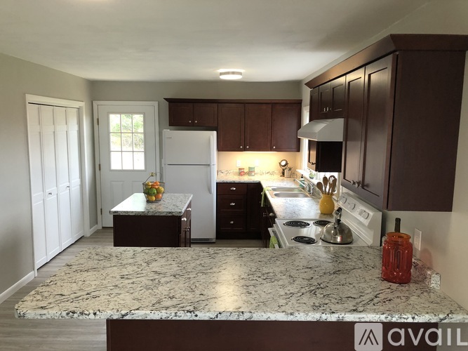 A kitchen with brown cabinets and a granite countertop.