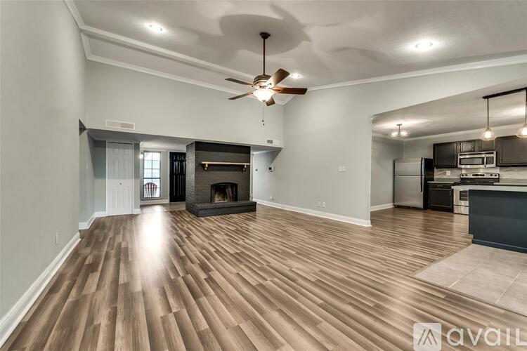 A spacious living room with a fireplace and hardwood floors.
