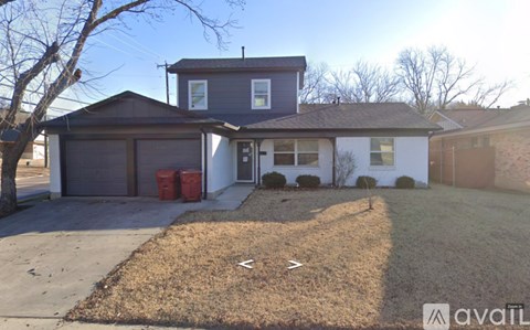 A house with a grey roof and a brown garage door.