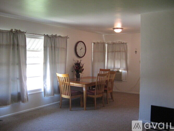 A dining room with a table and chairs.