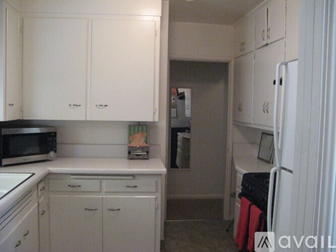 A kitchen with white cabinets and appliances.