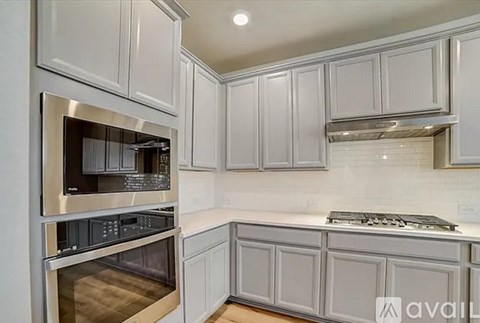 A kitchen with white cabinets and stainless steel appliances.