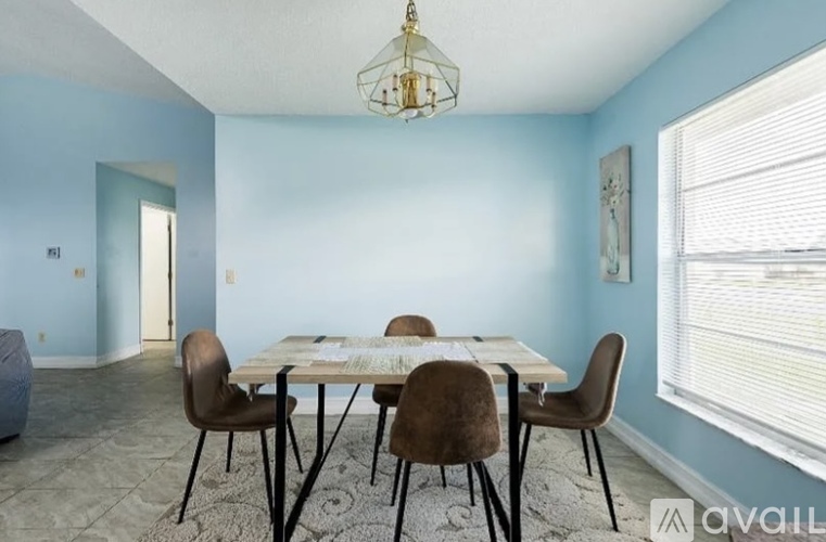 A dining room with a table and chairs.