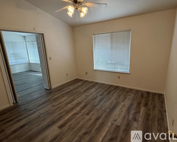 A room with wooden flooring and a ceiling fan.