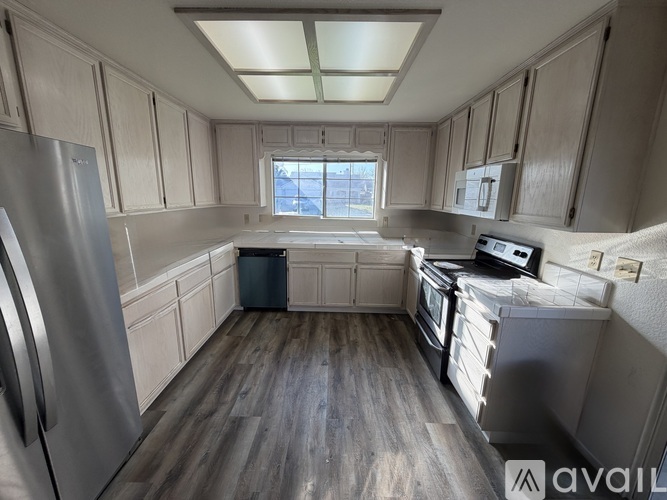 A kitchen with wooden floors and stainless steel appliances.