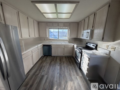 A kitchen with wooden floors and stainless steel appliances.