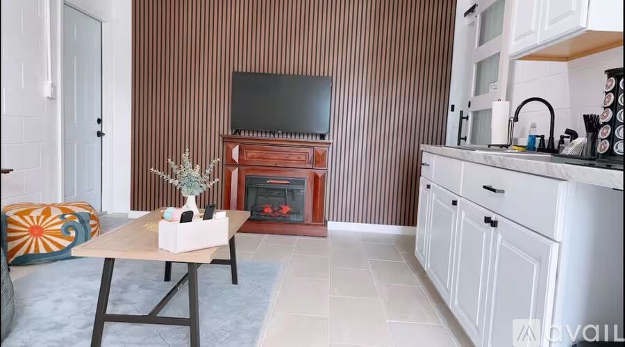 A living room with a fireplace and a television on the wall.