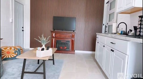 A living room with a fireplace and a television on the wall.