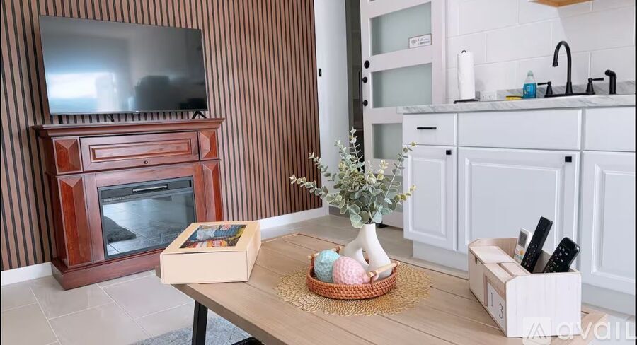 A living room with a wooden entertainment center and a white cabinet.