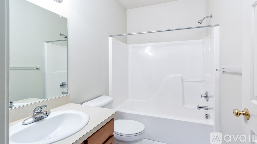 A white bathroom with a sink, toilet, and bathtub.
