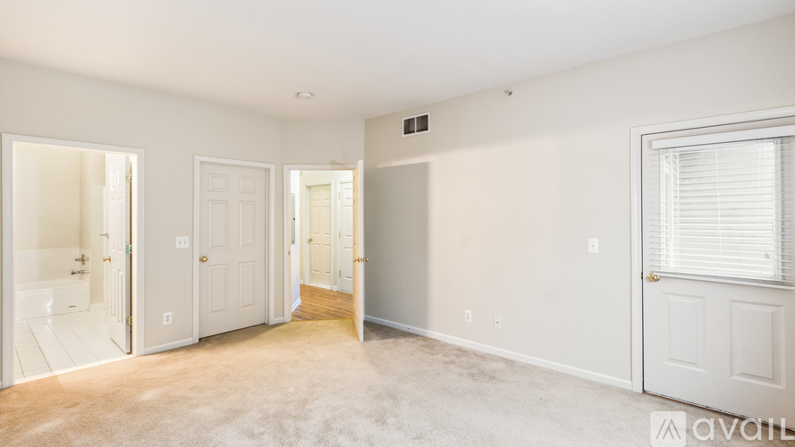 A spacious room with white walls and a carpeted floor.