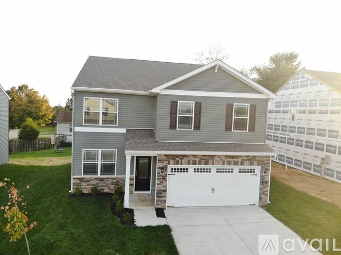 A house with a grey exterior and a white garage door.