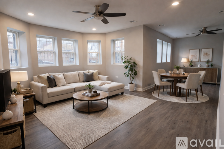 A living room with a white couch, a coffee table, and a dining table with chairs.