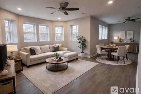 A living room with a white couch, a coffee table, and a dining table with chairs.