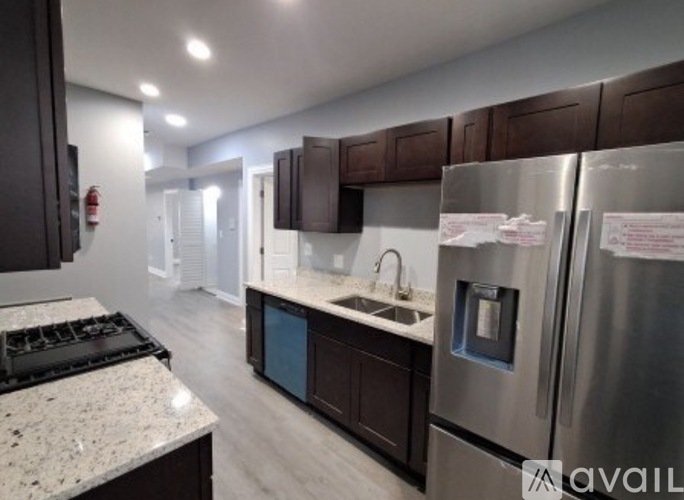 A modern kitchen with dark brown cabinets and stainless steel appliances.