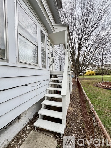 A white staircase is outside a house.