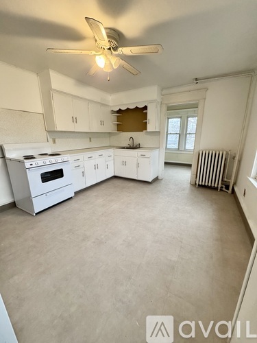 A white kitchen with a fan on the ceiling.