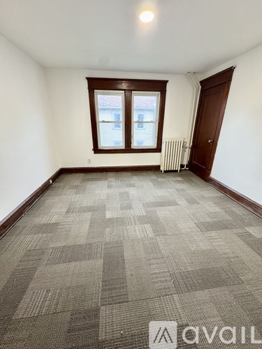 A room with a carpeted floor and a window.