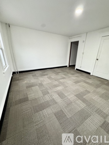 A room with a carpeted floor and white walls.