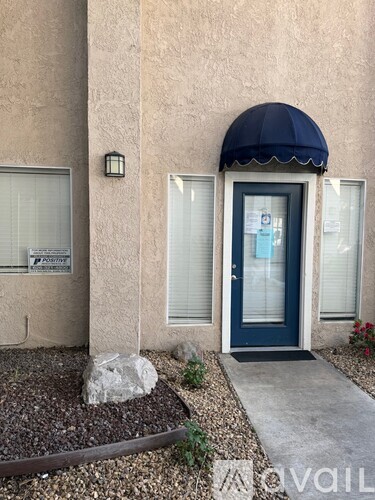 A building with a dark blue awning and a white sign on the window.