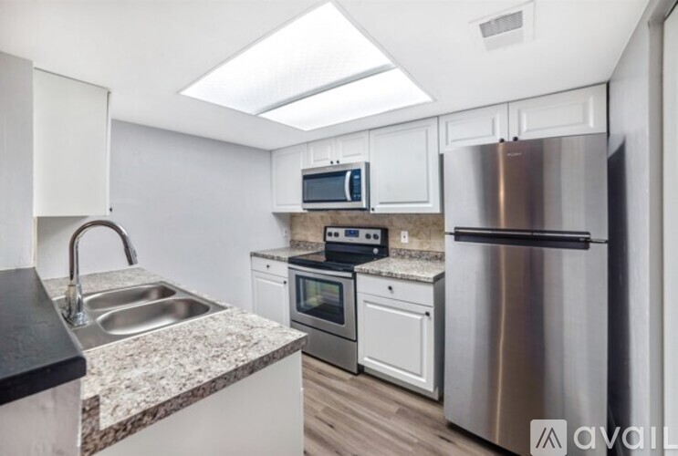A kitchen with a stainless steel refrigerator, microwave, oven, and sink.