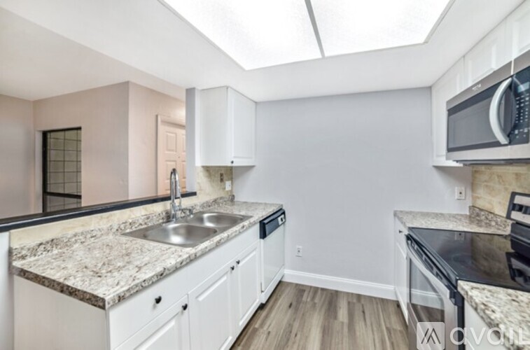 A kitchen with white cabinets and a granite countertop.