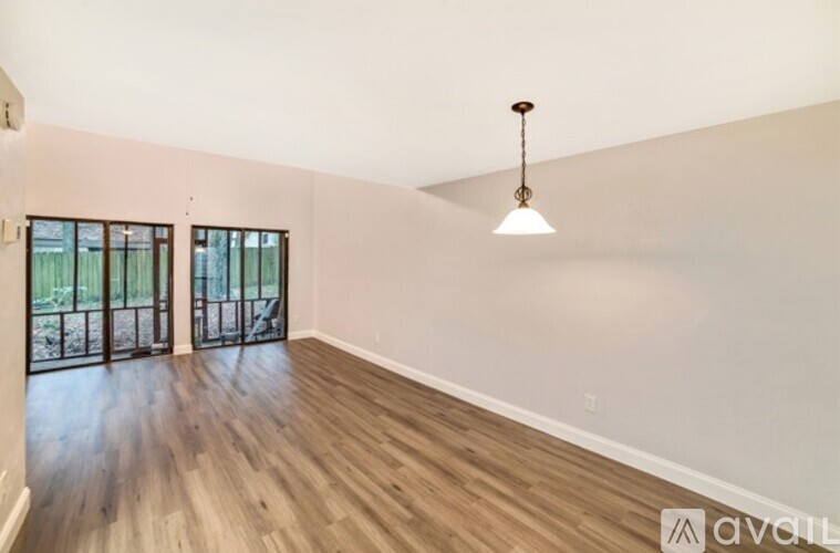 A room with wooden flooring and a hanging light fixture.