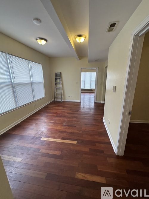 A room with wooden floors and a ladder in it.