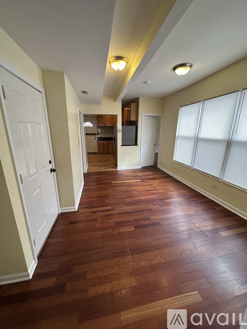 A hallway with wood floors and white doors.
