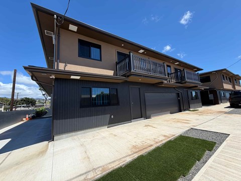 A modern two-story house with a balcony on the upper floor.