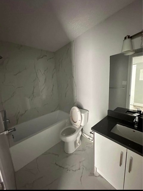 A bathroom with a toilet, sink, and bathtub.