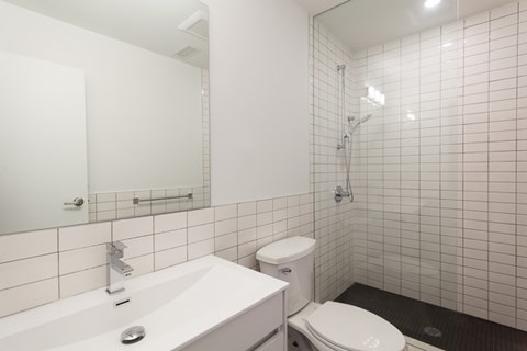 A white bathroom with a toilet, sink, and mirror.