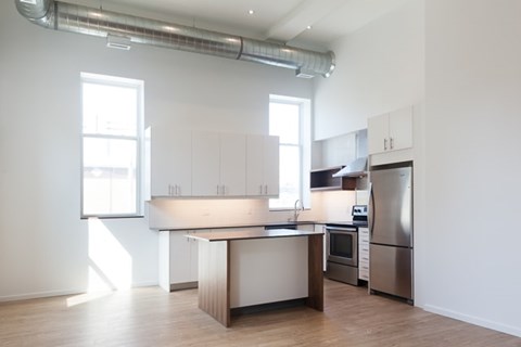 A kitchen with a refrigerator, microwave, and oven.