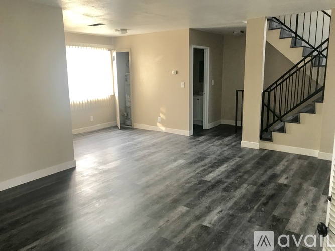 A spacious room with a staircase on the right side.