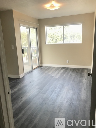 A room with a wooden floor and a window.