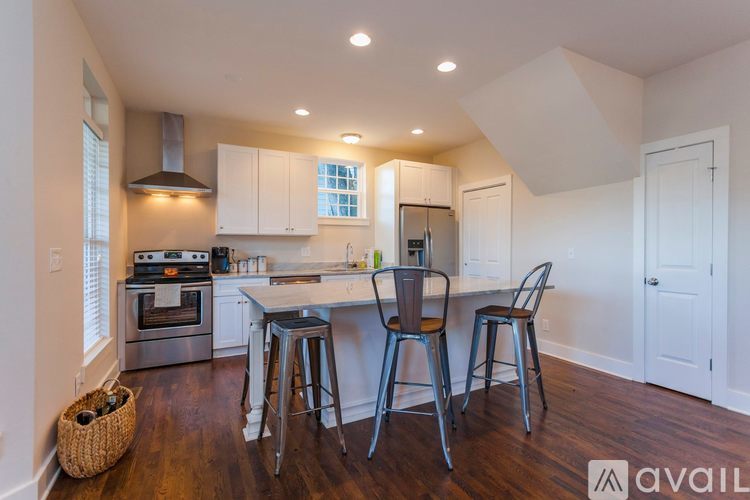 A kitchen with white cabinets and a wooden floor.