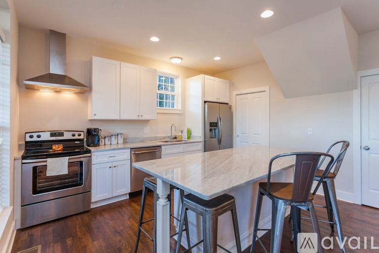 A kitchen with a white countertop and a stainless steel oven.