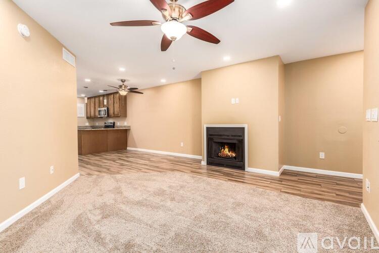 A living room with a fireplace and a ceiling fan.