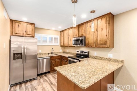 A kitchen with wooden cabinets and granite countertops.