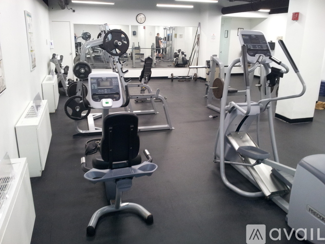 A gym with a variety of equipment including treadmills, weights, and exercise machines.