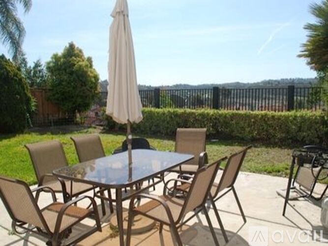 A patio table with chairs and an umbrella is set up on a patio.