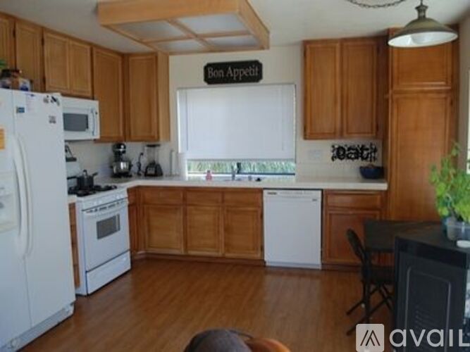 A kitchen with wooden cabinets and a white fridge.