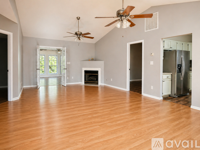 A room with a ceiling fan and wooden flooring.