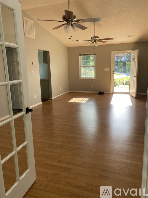 A room with wooden floors and a ceiling fan.