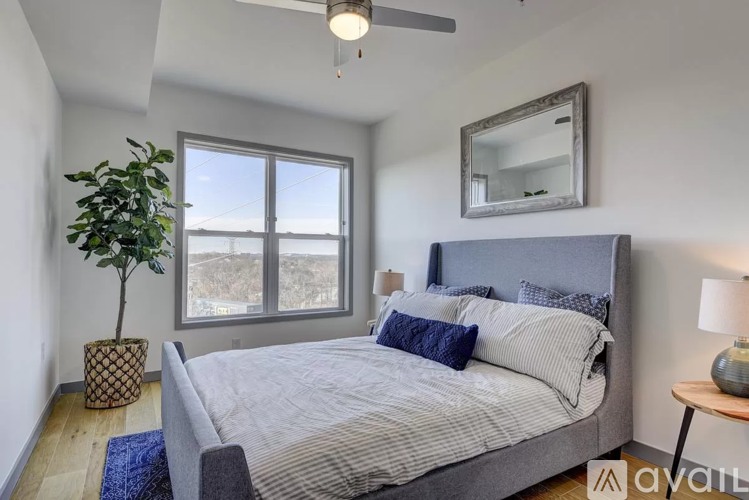 A bedroom with a large bed and a view of the outdoors through the window.