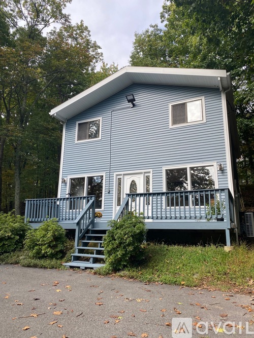 A blue house with a white roof and a porch.
