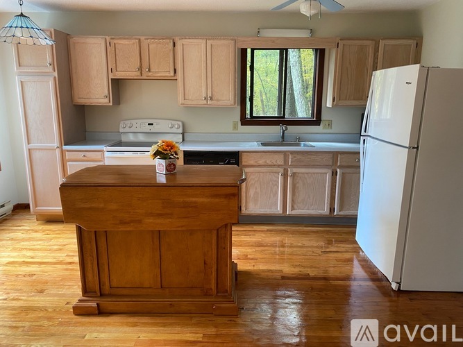 A kitchen with wooden cabinets and a white refrigerator.