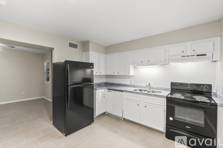 A kitchen with black and white appliances and cabinets.